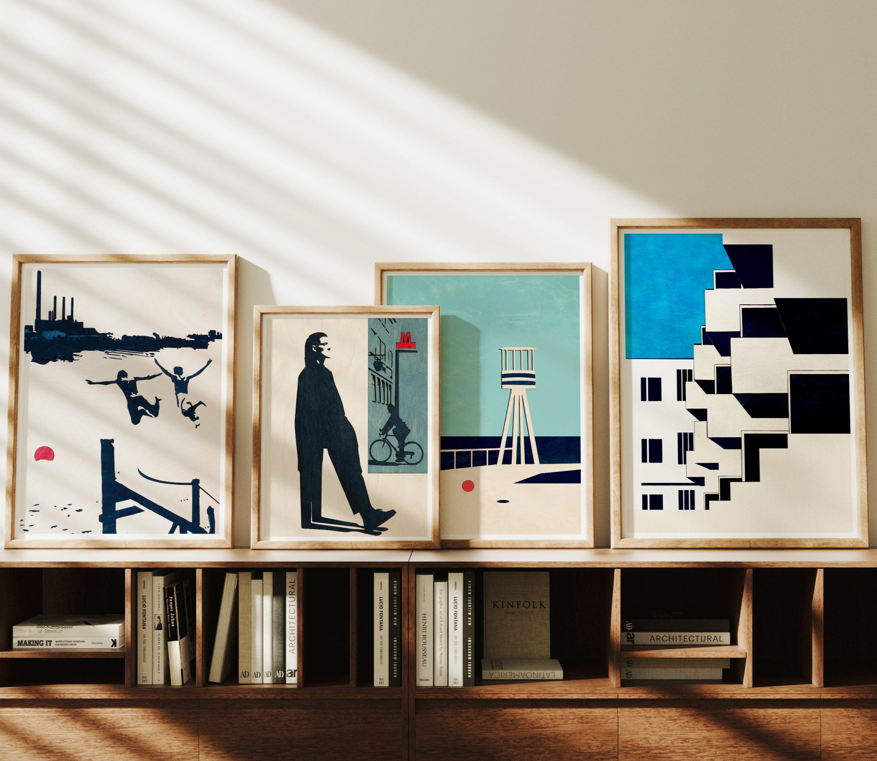Framed artworks on a wooden shelf with books